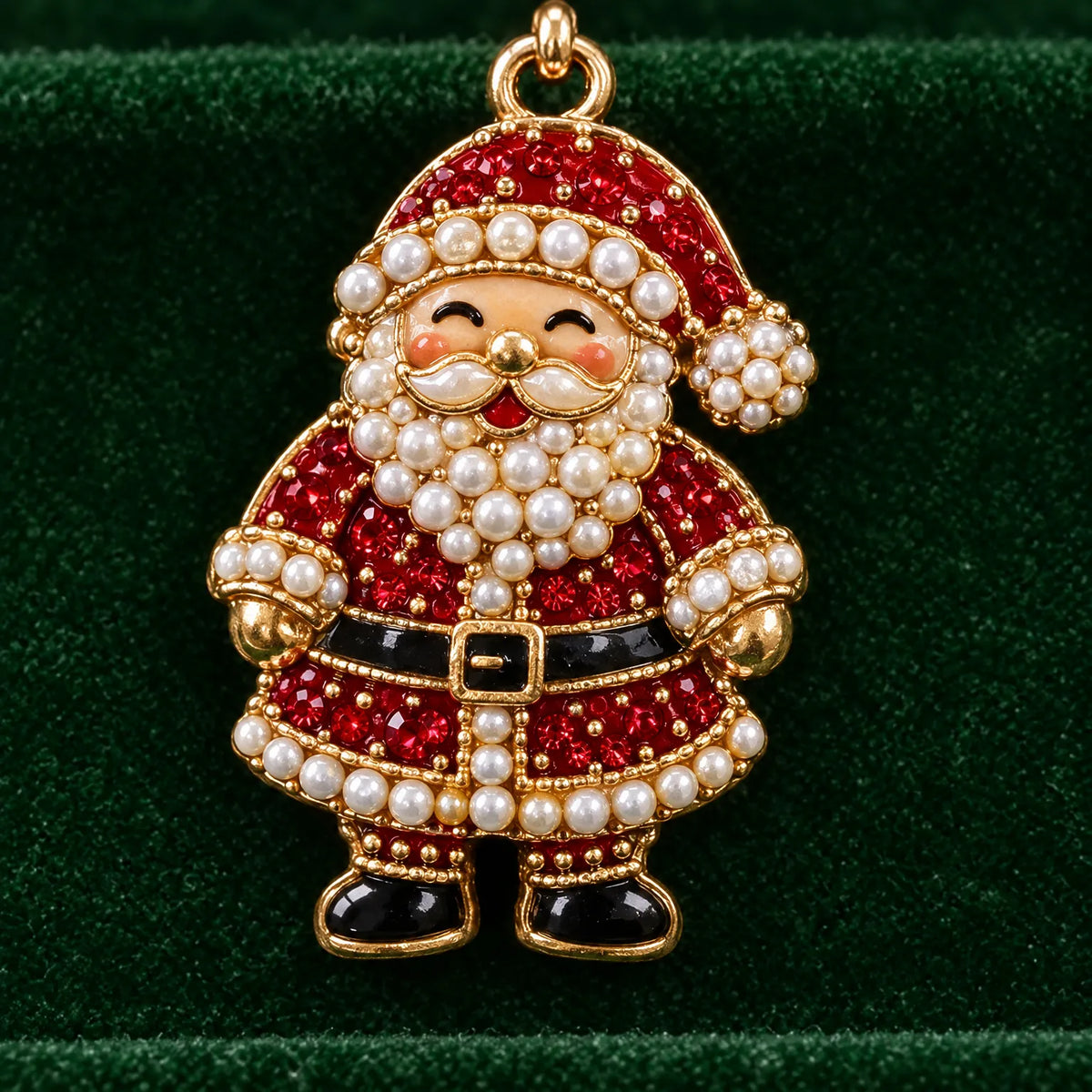 Närbild på ett hänge format som en leende tomte med röda stenar, vita pärlor och guldkant mot grön sammet. 3