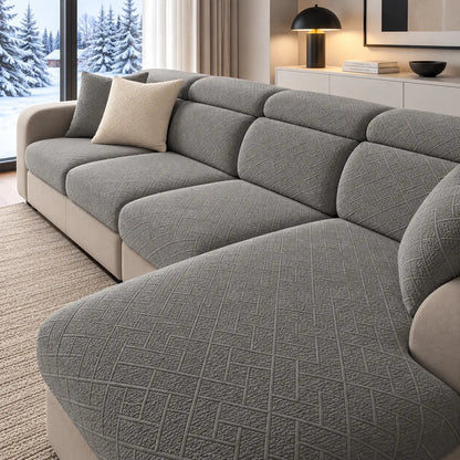 Hörnsoffa med grå texturerade överdrag, en krämfärgad kudde och snölandskap utanför 20