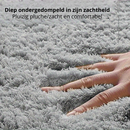 Hand auf grauem, flauschigem Teppich, weich und komfortabel, Nahaufnahme.