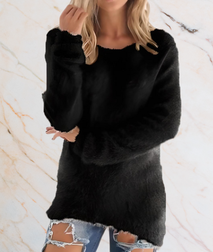 Frau in schwarzem Pullover aus Kunstfell, zerrissene Jeans, Marmorhintergrund.