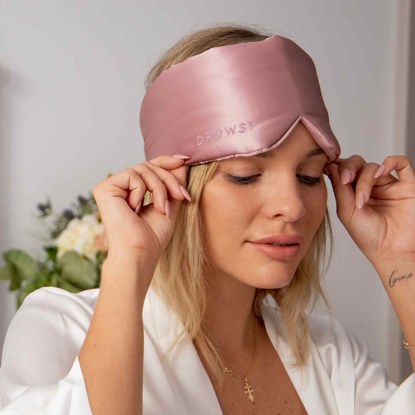 Blonde Frau mit rosa Seiden-Schlafmaske, Drowsy, luxuriös, bequem, Schlafaccessoire.