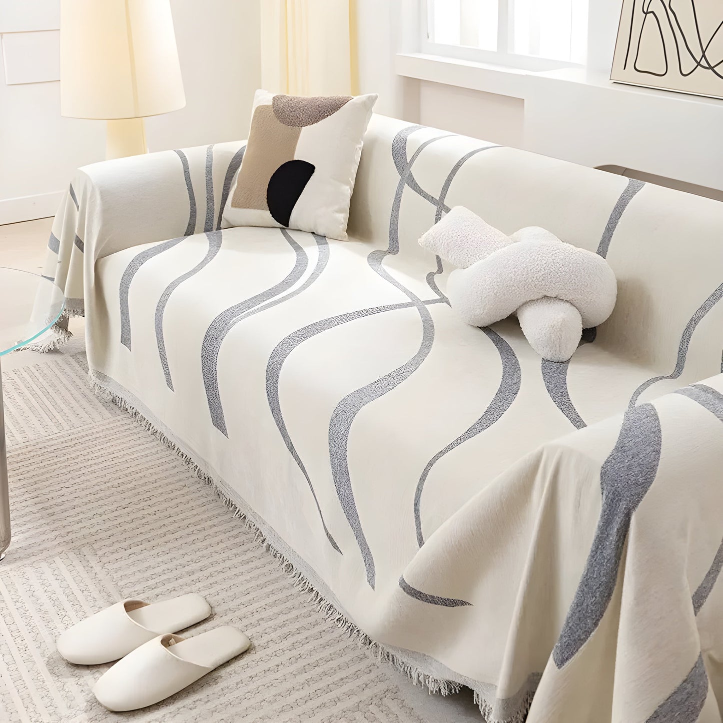 Beige Sofa mit grauem Wellenmuster, dekoriert mit Kissen, in modernem Wohnzimmer, Tageslicht.