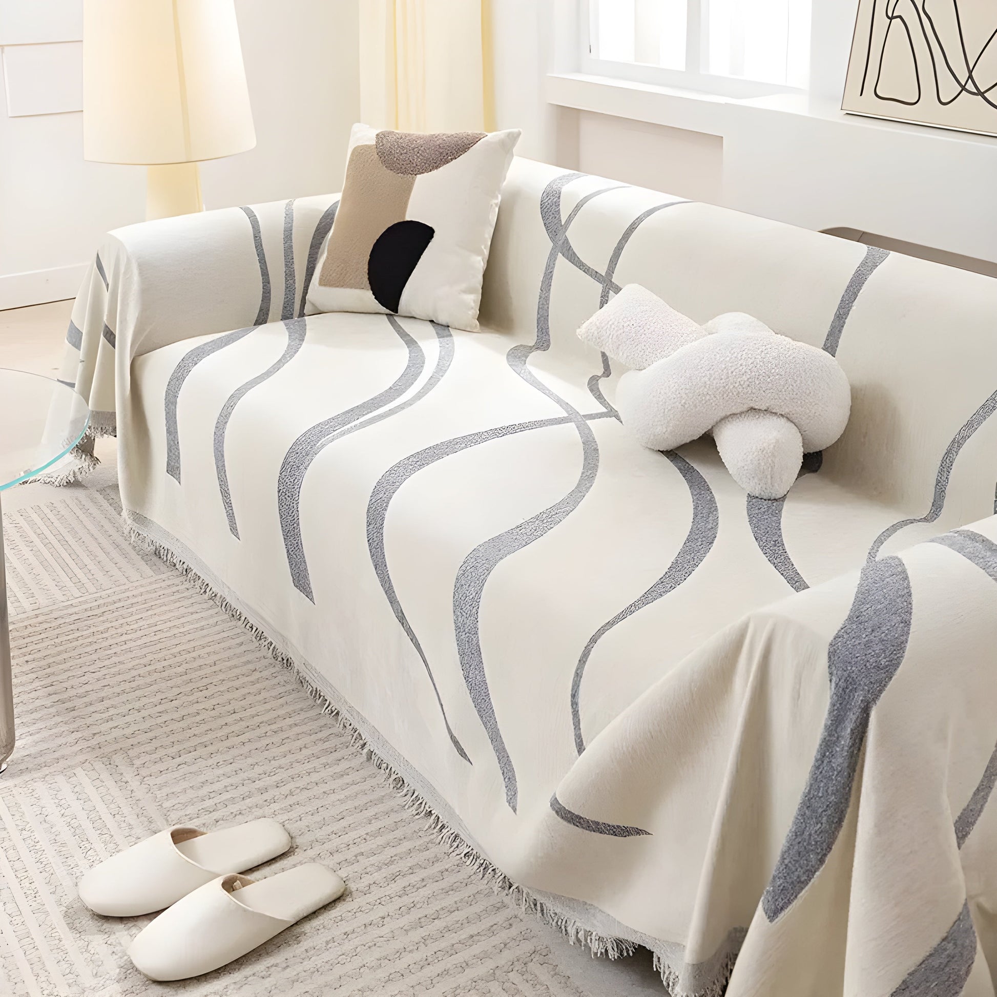 Beige Sofa mit grauem Wellenmuster, dekoriert mit Kissen, in modernem Wohnzimmer, Tageslicht.