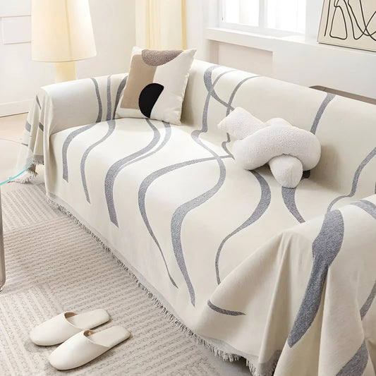 Beige Sofaüberwurf mit grauem Wellenmuster, dekoratives Kissen, modernes Wohnzimmerdesign.