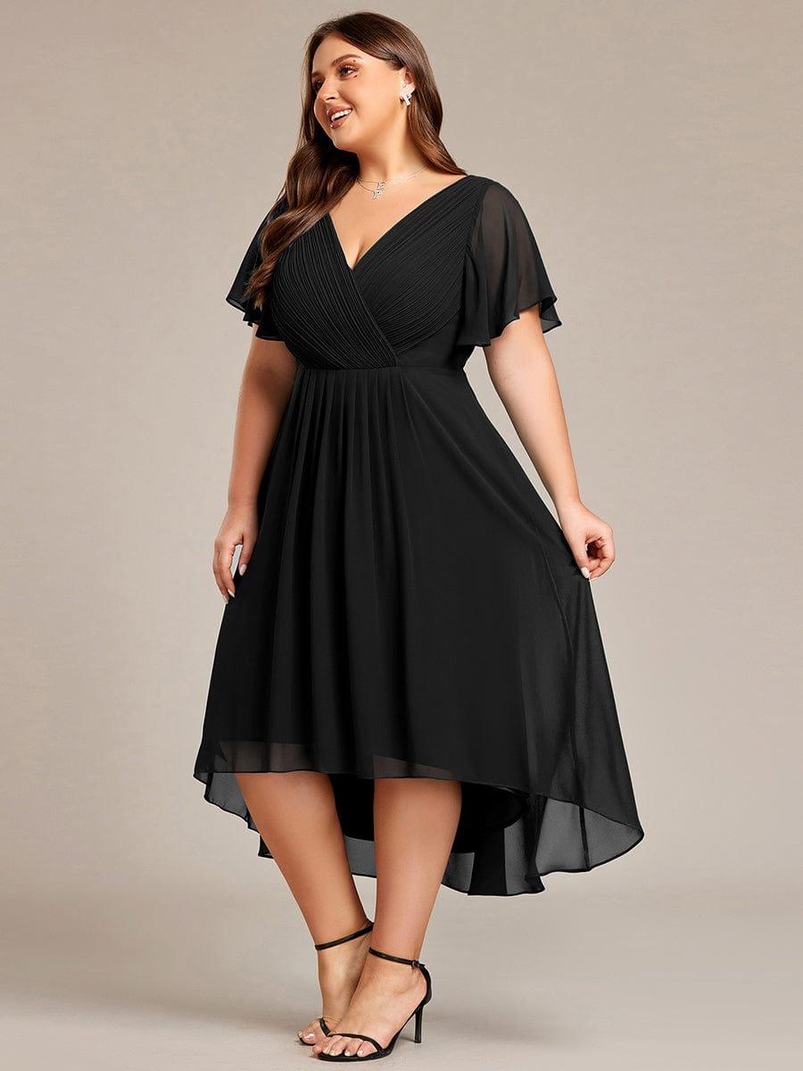 Svart klänning på plus size-modell snett framifrån, där den högre fronten och längre, fladdriga bakkanten syns. 29