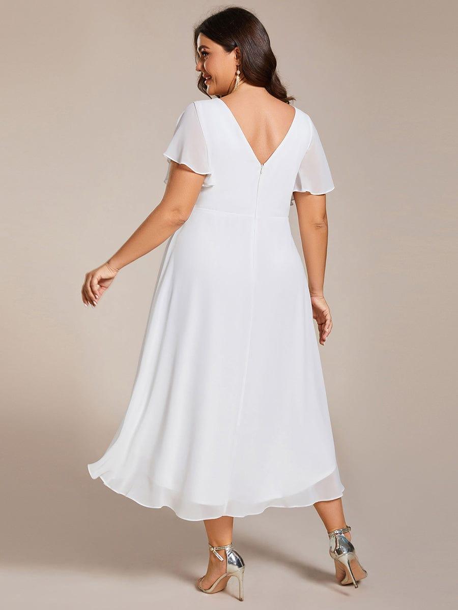 Plus size-modell i vit klänning sedd bakifrån, med V-ringad rygg, dragkedja och längre bakkant. 74