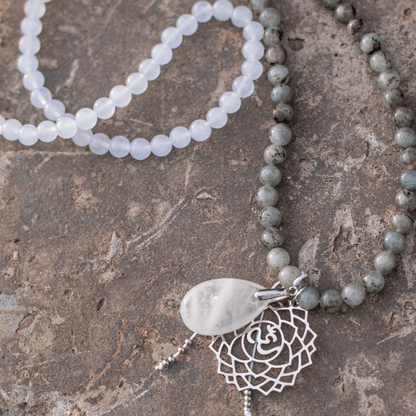 Halskette mit weißen und grauen Perlen, silberner Anhänger, handgefertigter Schmuck.