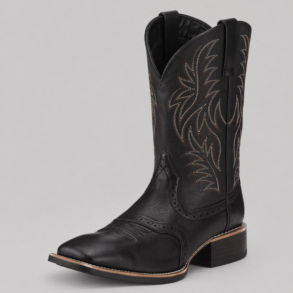 Svart cowboystövel med ljus broderad skaftdekor, snett framifrån mot grå bakgrund 1