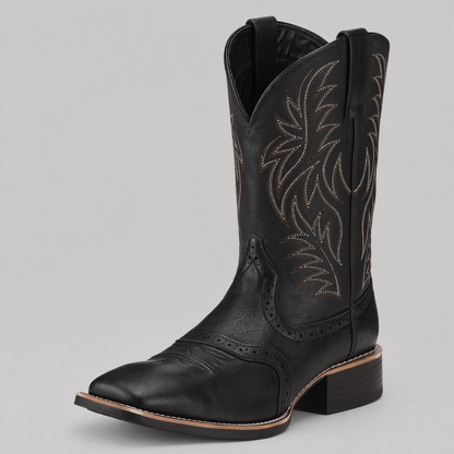 Svart cowboystövel med ljus broderad skaftdekor, snett framifrån mot grå bakgrund 1