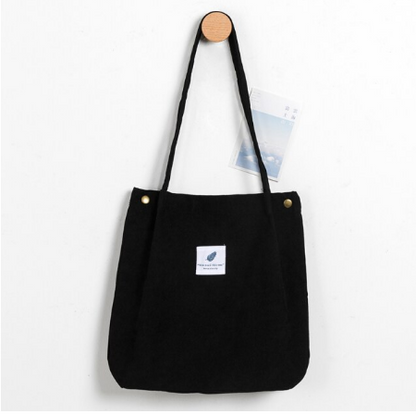 Schwarze Stofftasche mit langen Henkeln, minimalistisches Design, ideal für den Alltag.