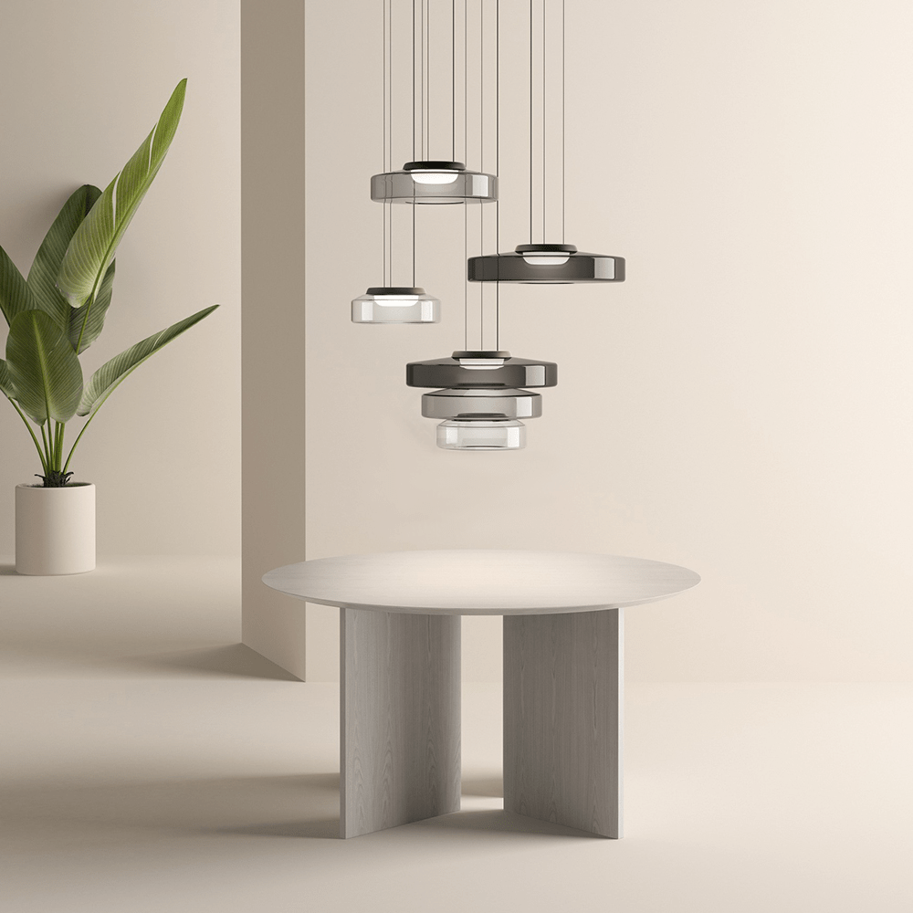 Moderne Hängelampen über rundem Holztisch, minimalistisches Design, neutrale Farben.