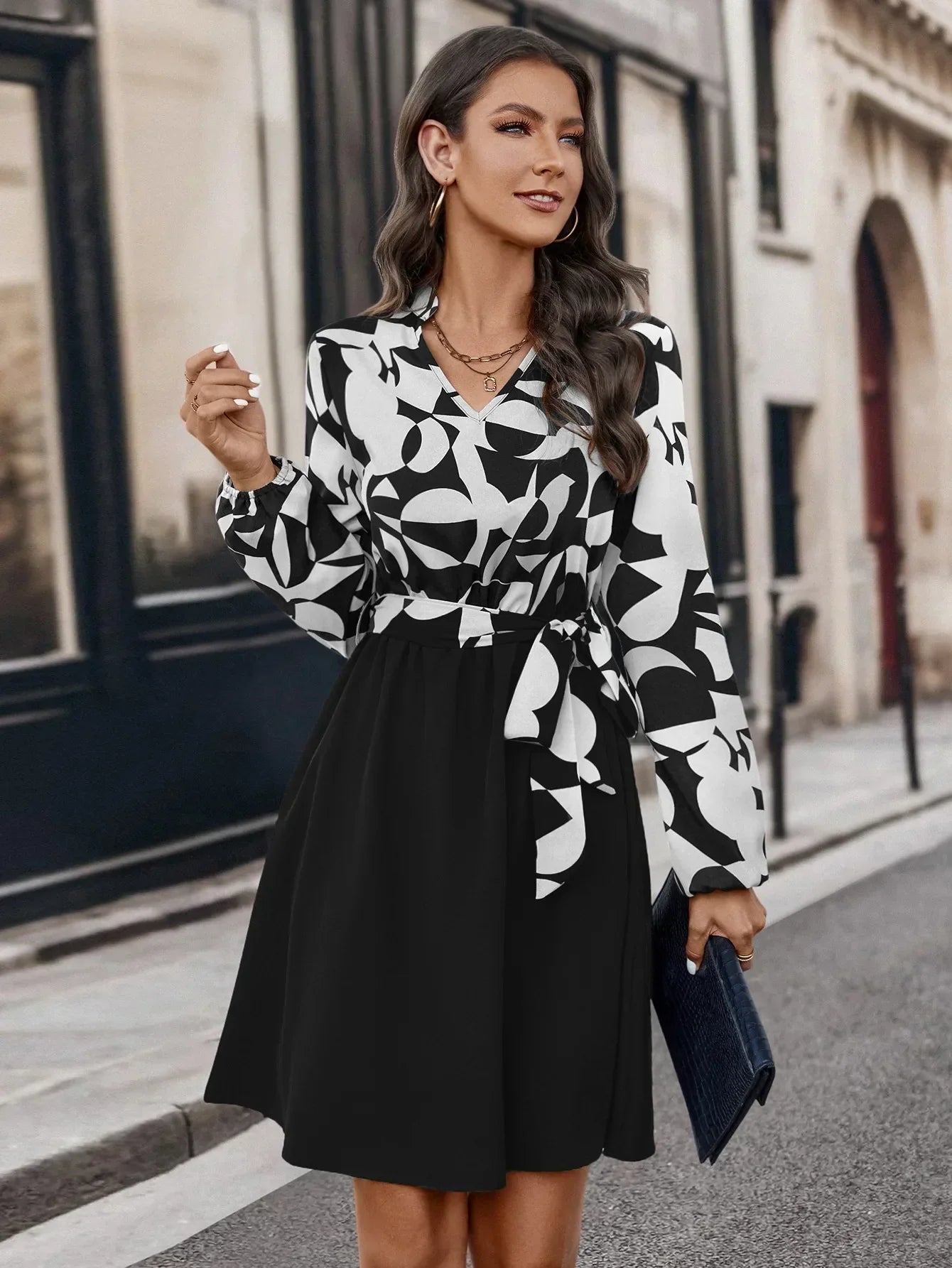 Elegantes Damenkleid mit V-Ausschnitt, langen Ärmeln, schwarz-weißem Print, ideal fürs Büro.