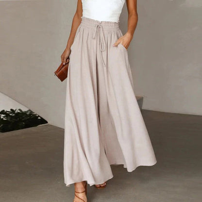 Frau in beigen, weiten Hosen aus Leinen, Sommermode, lässiger Stil, elegante Damenbekleidung.