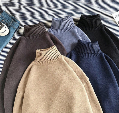 Fünf Rollkragenpullover aus Wolle in Beige, Grau, Blau, Schwarz auf gestreiftem Hintergrund.
