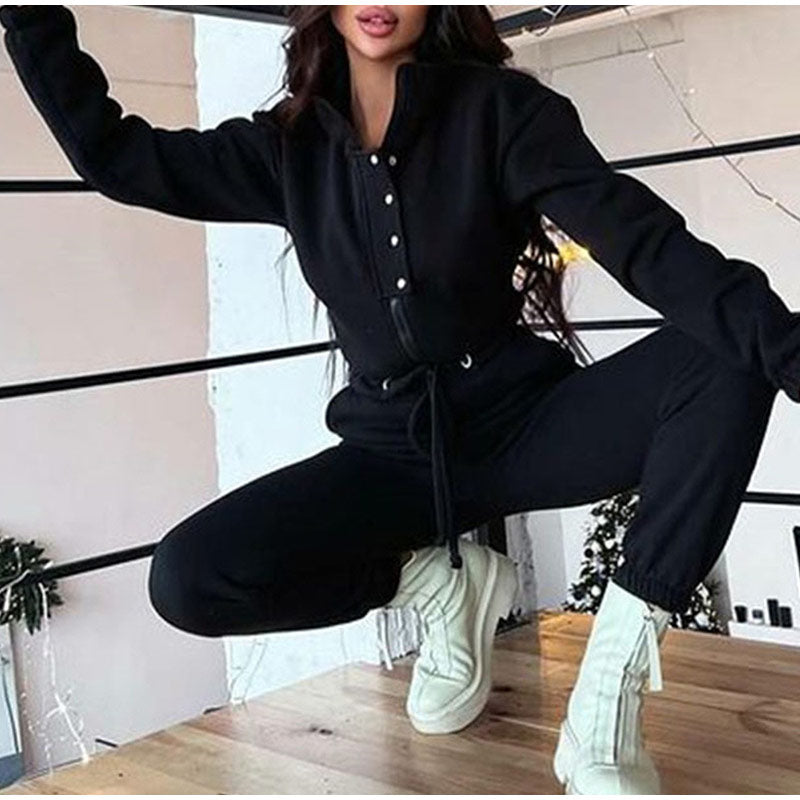 Frau in schwarzem Jumpsuit und weißen Stiefeln, modische Freizeitkleidung, Indoor-Aufnahme.