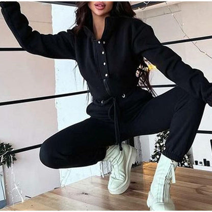 Frau in schwarzem Jumpsuit und weißen Stiefeln, modische Freizeitkleidung, Indoor-Aufnahme.