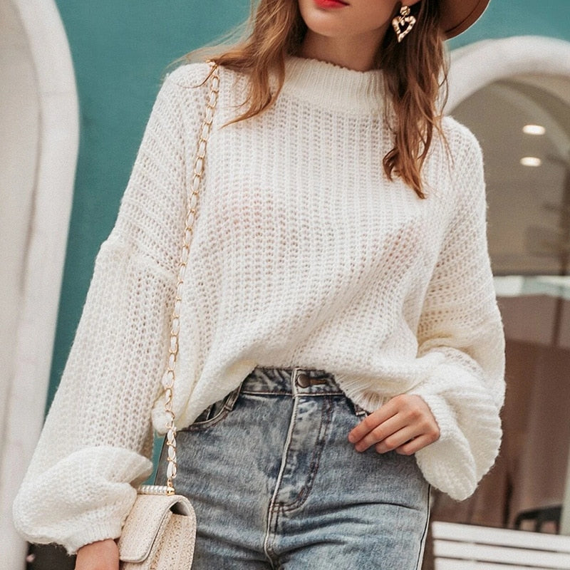 Frau in weißem Strickpullover, blaue Jeans, beige Tasche, modisch, lässig, Herbstmode.