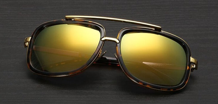 Sonnenbrille mit goldenen Gläsern, rechteckigem Rahmen, Metallbügel, modisch, unisex.