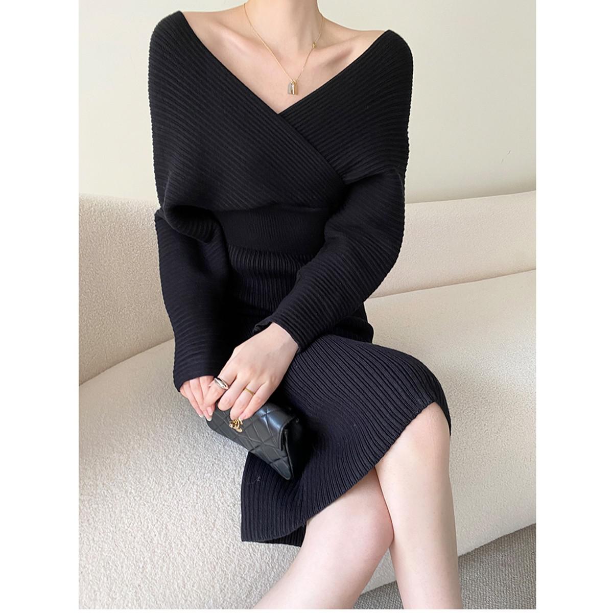 Frau in schwarzem Strickkleid, sitzt auf Sofa, hält schwarze Clutch, elegantes Outfit.