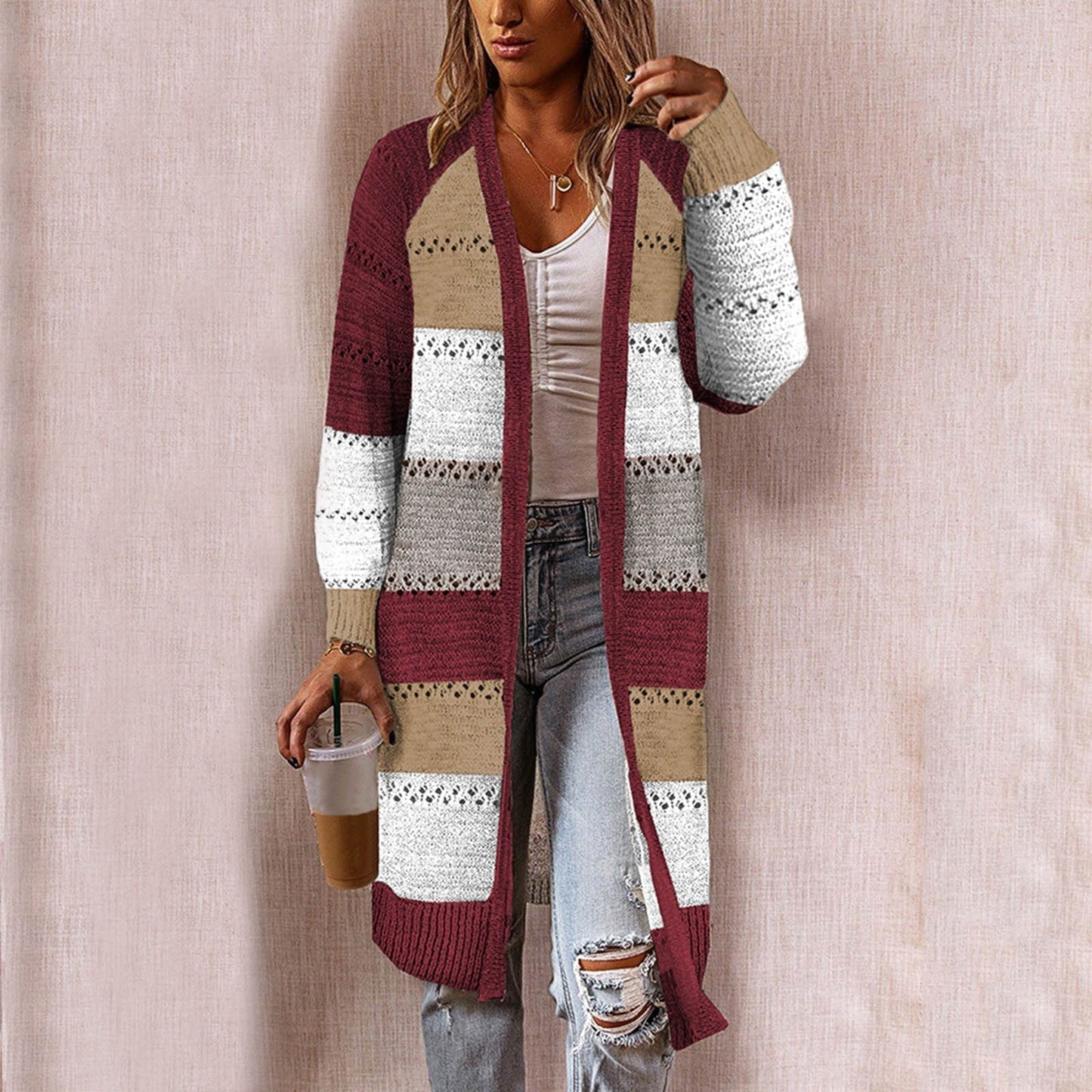 Frau trägt gestreiften Strick-Cardigan in Rot, Beige, Weiß; lässiger Herbst-Look.