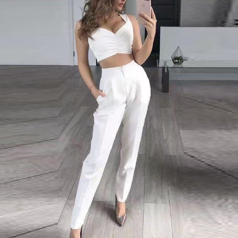 Frau in weißem, ärmellosem Crop-Top und Hose, modisch, elegant, Selfie, Innenraum.