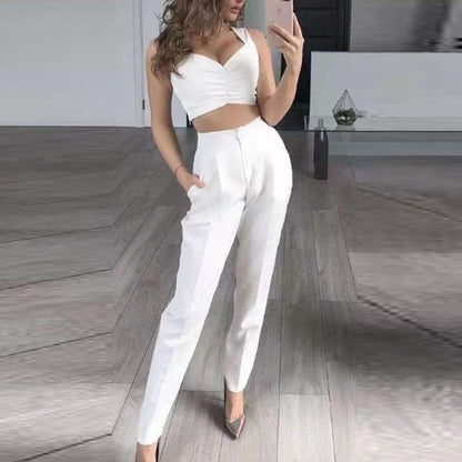 Frau in weißem, ärmellosem Crop-Top und Hose, modisch, elegant, Selfie, Innenraum.