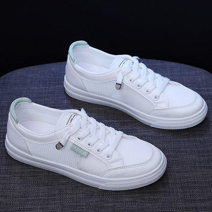 Weiße Sneaker aus Canvas mit Schnürsenkeln, modisch, unisex, auf grauem Hintergrund.