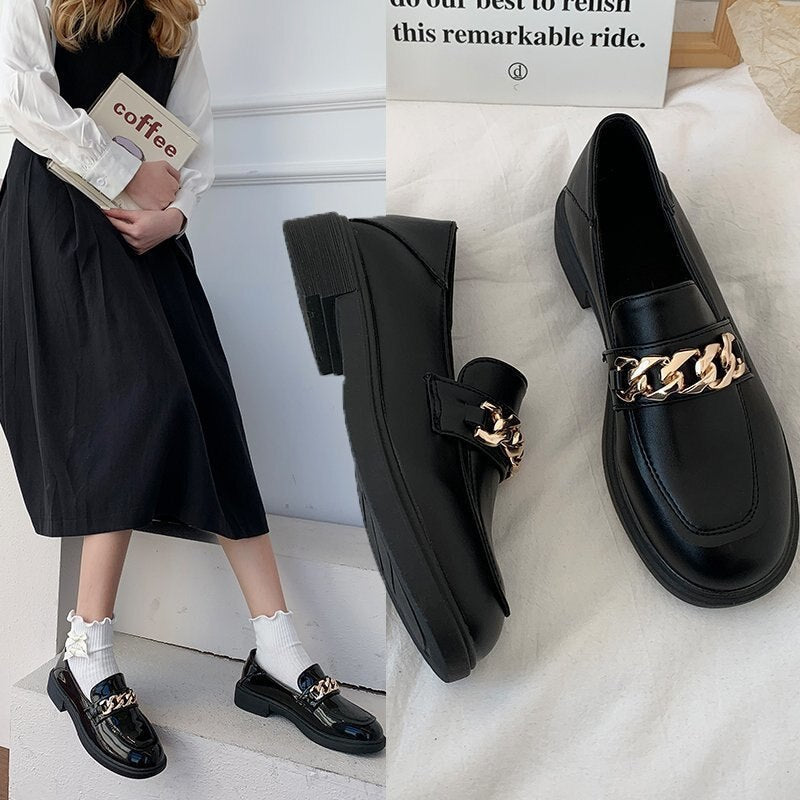Schwarze Loafer mit goldener Kette, Damenmode, elegantes Design, Lederoptik, Herbstschuhe.