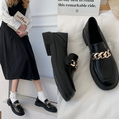 Schwarze Loafer mit goldener Kette, Damenmode, elegantes Design, Lederoptik, Herbstschuhe.