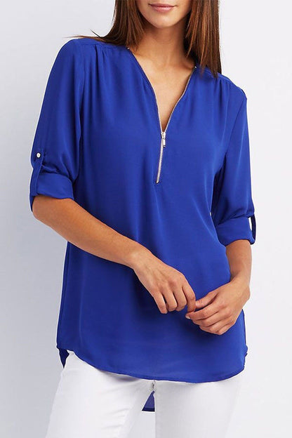 Frau in blauer Bluse mit Reißverschluss, 3/4-Ärmeln, modisch, elegant, Damenmode.