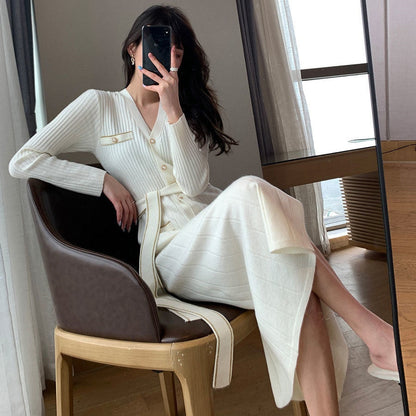 Frau in weißem Strickkleid, sitzt auf Stuhl, modernes Interieur, Selfie im Spiegel.