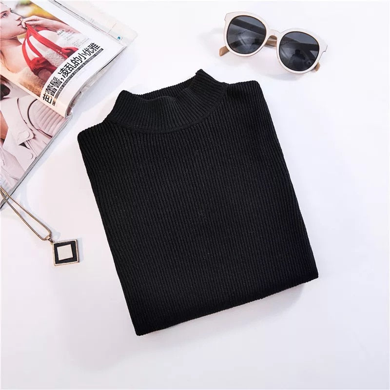 Schwarzer Rollkragenpullover aus Strick, Damenmode, elegant, Herbst-Winter, neben Sonnenbrille.