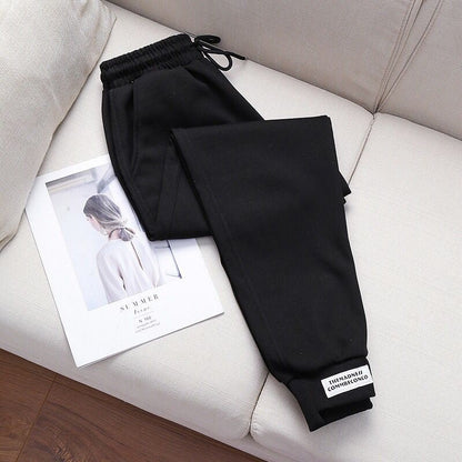 Schwarze Jogginghose aus Baumwolle auf Sofa, lässige Sportbekleidung für Damen.