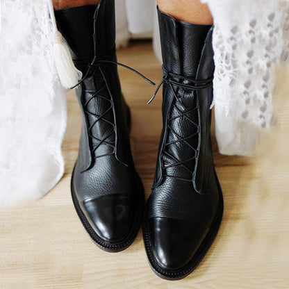 Schwarze Lederstiefel mit Schnürung, Damenmode, elegantes Design, auf Holzboden.