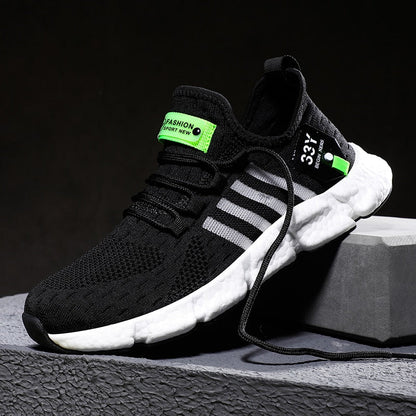 Schwarzer Sportschuh mit weißen Streifen, grünen Akzenten, atmungsaktivem Mesh-Obermaterial.