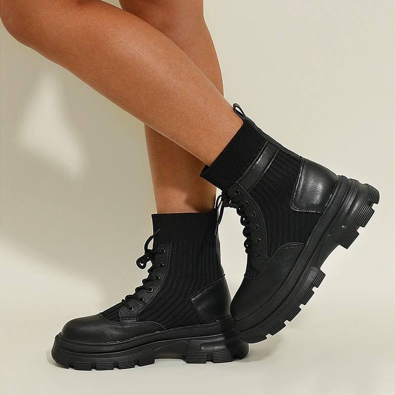 Schwarze Damenstiefel mit dicker Sohle, Schnürung und Strickschaft, modisch und robust.