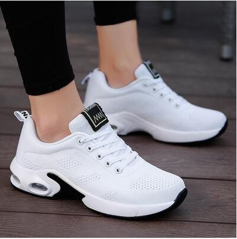 Weiße Damen-Sneaker, atmungsaktiv, sportlich, mit schwarzer Sohle, ideal für Freizeit und Sport.