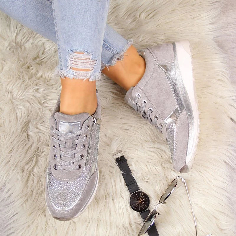 Uppifrån av gråa sneakers på en lurvig matta, med ett armbandsur och solglasögon bredvid. 6