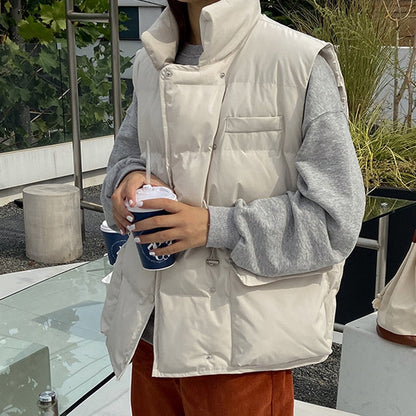 Frau in weißer Daunenweste, grauem Pullover, hält Kaffee, Herbstmode, Outdoor-Café.