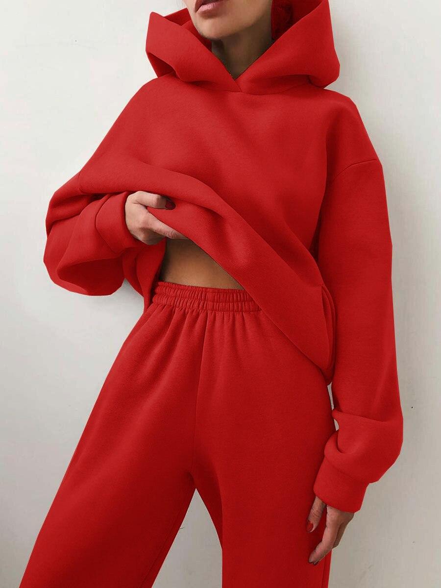 Frau in rotem Kapuzenpullover und Jogginghose, gemütliche Freizeitmode, Streetwear-Look.