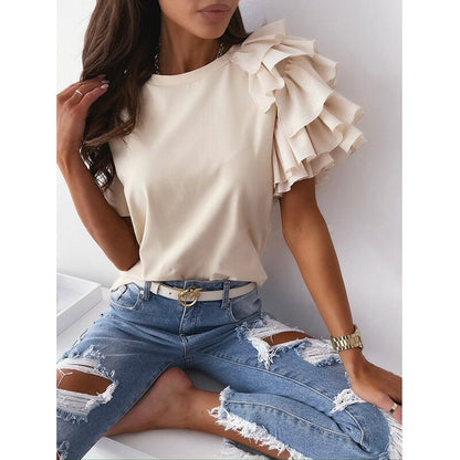 Frau in cremefarbenem Rüschen-Top und zerrissener Jeans, modisch, elegant, Freizeitkleidung.