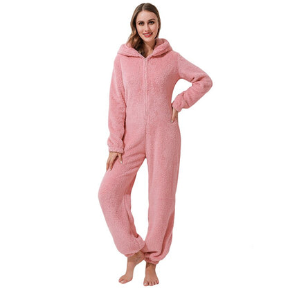 Frau in rosa Fleece-Overall mit Kapuze, gemütlicher Einteiler, Damenmode, Winterbekleidung.