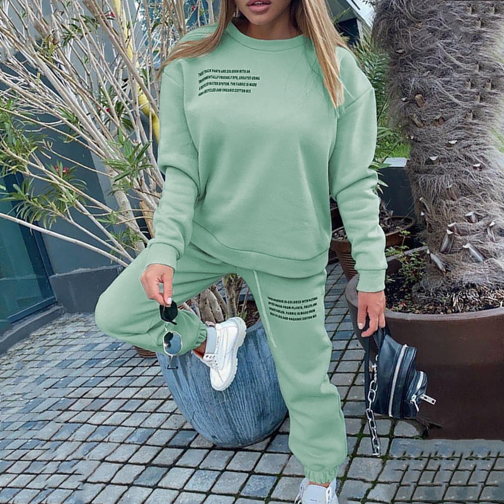 Frau in grünem Jogginganzug, Sneakers, schwarze Tasche, draußen, modisch, bequem.