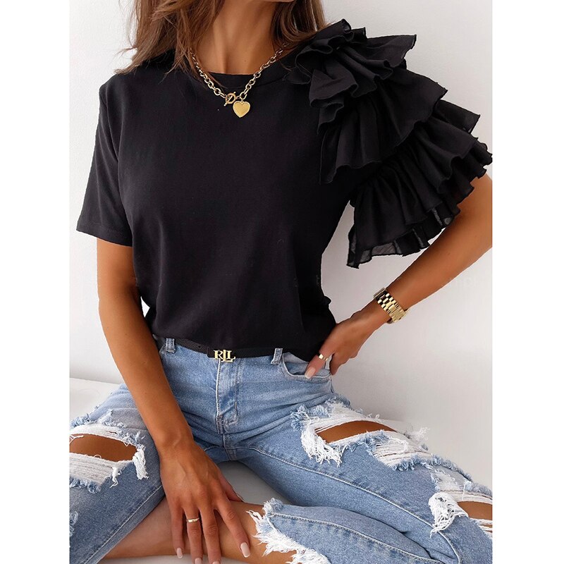 Frau in schwarzem Rüschen-T-Shirt und zerrissenen Jeans, modisches Outfit, lässiger Stil.
