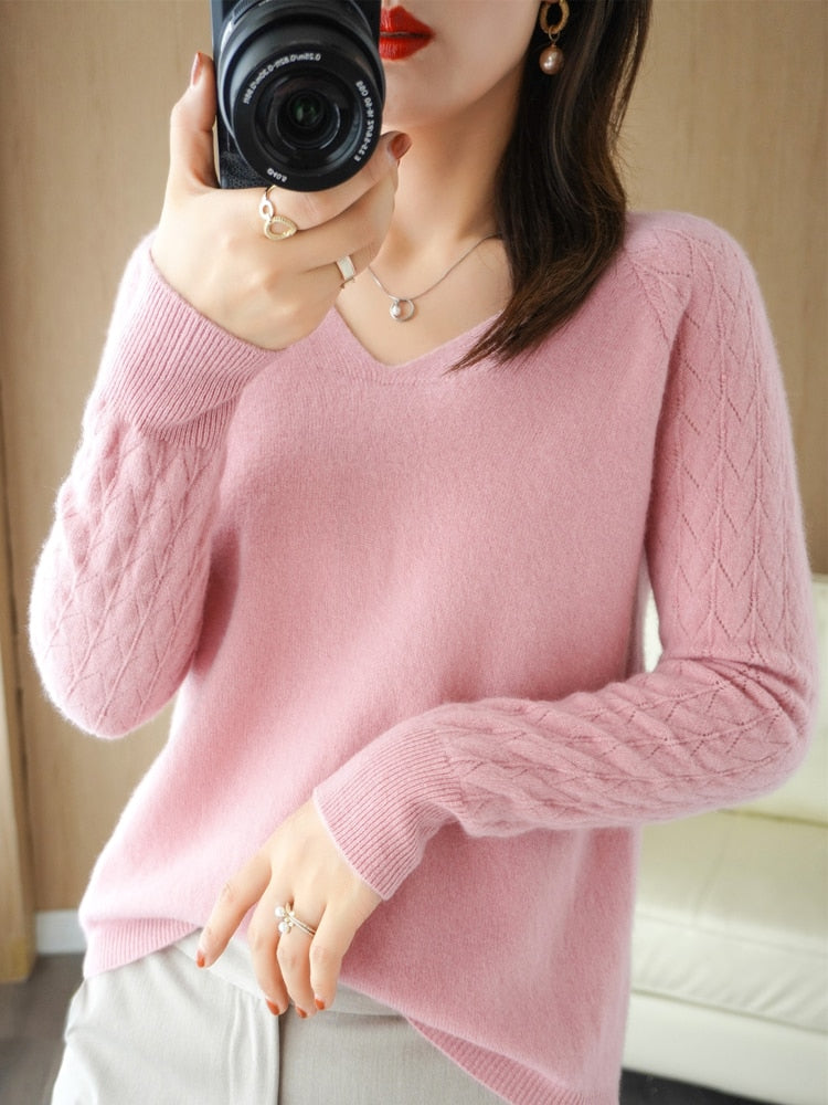 Frau in rosa Kaschmirpullover mit Kamera, elegantes Design, V-Ausschnitt, Zopfmuster.