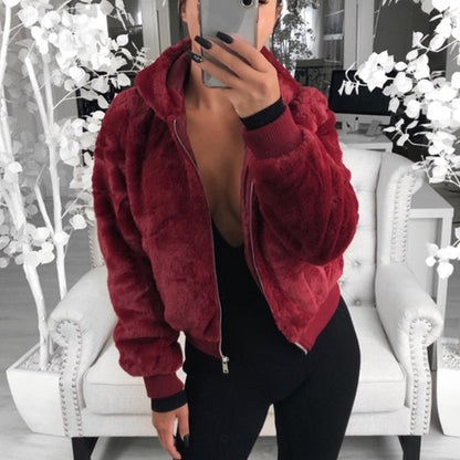 Frau in roter Kunstpelzjacke, Reißverschluss, Kapuze, modisch, gemütlich, Innenraum.