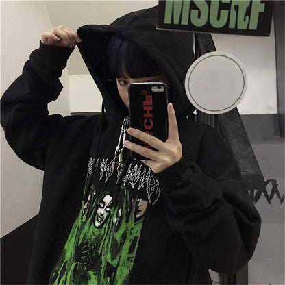 Person in schwarzem Hoodie mit grünem Print, Selfie im Spiegel, Streetwear, urbaner Stil.