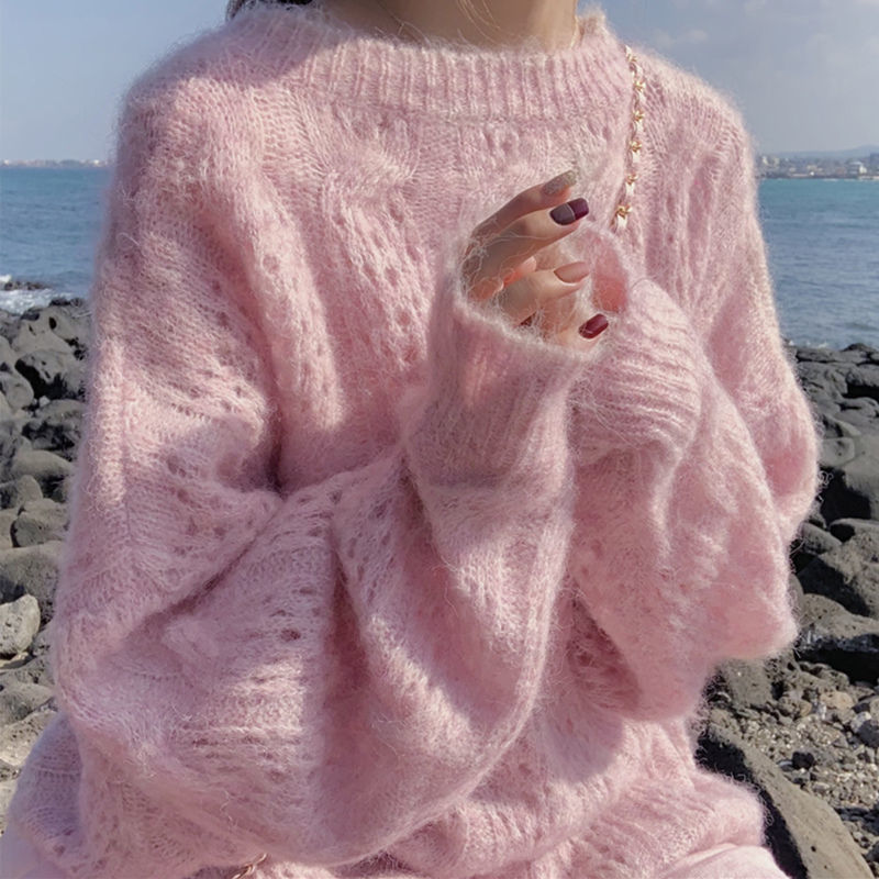 Frau in rosa Strickpullover aus Mohair am Meer, modisch, warm, gemütlich.