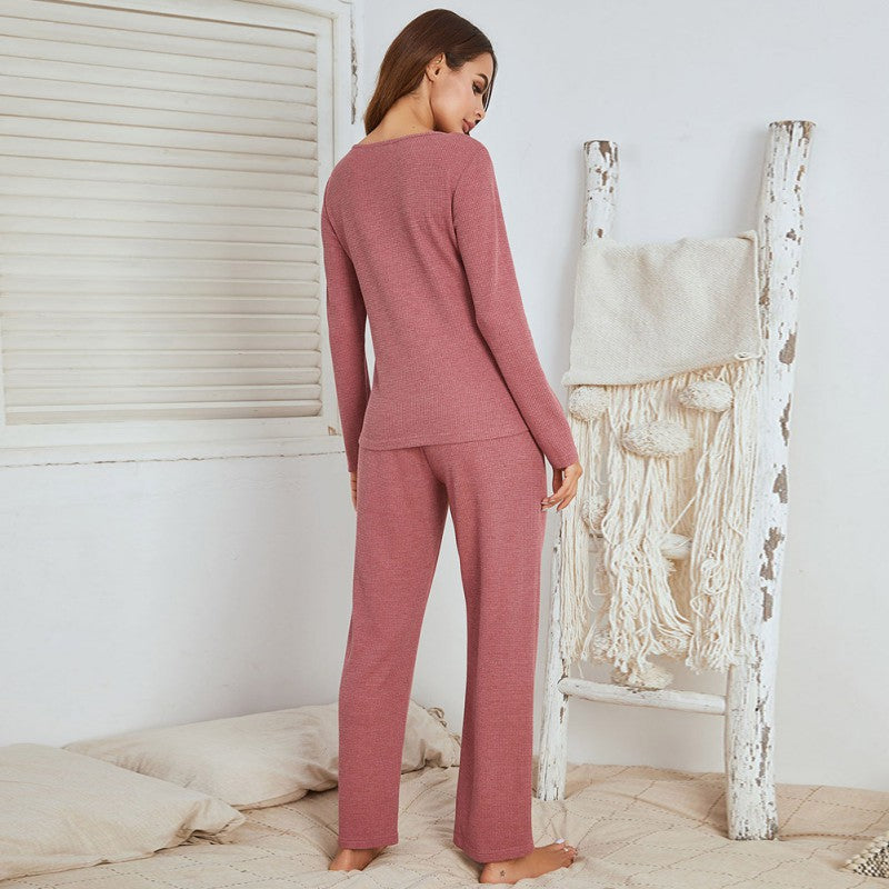 Frau in rosa Pyjama-Set aus Baumwolle, gemütlich, Schlafzimmer, entspannte Atmosphäre.