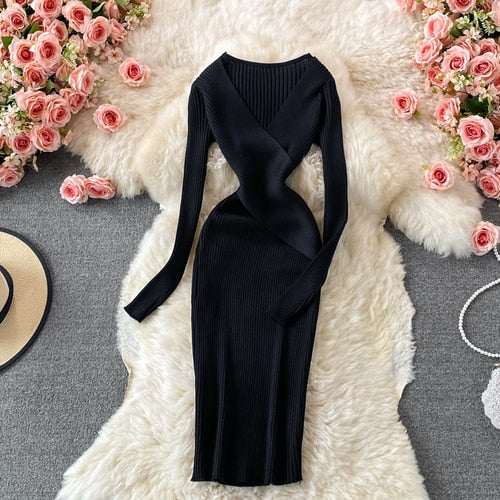 Schwarzes Strickkleid, langärmelig, figurbetont, auf weißem Fell, umgeben von rosa Rosen.